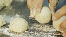 Close up on chef hands while preparing dough for pita bread.