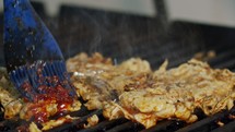 Close up of chicken breast roasted on a grill with flames.