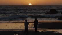 Sun sets with couple watching 