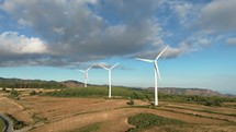 Wind power plant electric generator spinning in the mountains, aerial view