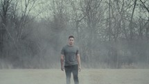 a man walking through a dusty field 
