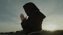 Silhouette Of A Monk Stands Praying On The Nature