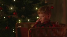 Child Reading the Bible by the Christmas Tree