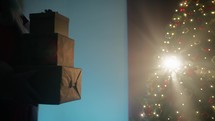 Silhouette of Santa Claus bringing heavy gifts for Christmas surprise 