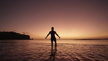 Silhouette of Man Walking on The Beach toward the Sunset with Dramatic Colorful Sky - Freedom, Motivation and Hopefulness