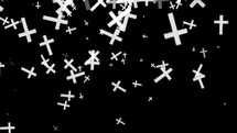 Particles of  white religious crucifixes pass on the black background