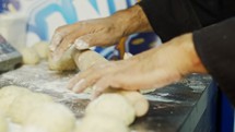 Close up on chef hands while preparing dough for pita bread.