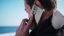 Boy Talks On The Phone At The Sea