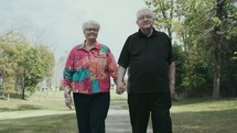 senior couple walking holding hands 