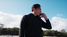 Boy Talks On The Phone At The Sea