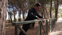 Hand Of A Man Dressed In Black Tracksuit Does Push Up Exercises On The Railing