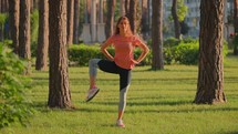 Woman stretching to warm up for exercise in a park