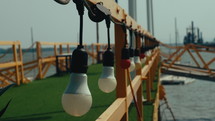 The path to the pier has light bulbs mounted on the bridge. Dolly shot
