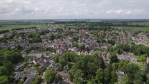 Aerial orbiting over beautiful small town of Loenen Aan De Vecht among lush trees and river. Netherlands