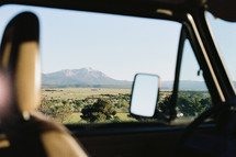 view of a mountain out a car window 
