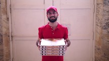 Smiling pizza delivery man with boxes