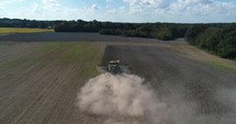 Harvester stirring up dust in a field 