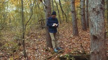 a man reading a Bible in a forest 