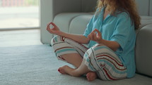 practicing yoga and meditation in apartment morning routine for calmness unrecognizable woman sitting on the floor with crossed legs