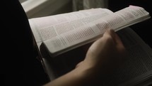 Young white male hands on open bible. Studying and reading scriptures in the holy bible. Christian religion and daily devotionals are a part of this young mans daily activities.