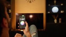 Man change color light of the house with smart phone, home automation concept
