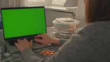 woman using laptop with green screen online consultation with doctor chatting with therapist