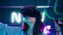 Woman moving her arms and head around as she plays a virtual reality game.