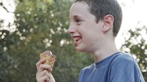 Young boy eating Ice Cream from a cone, enjoying and laughing
