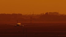passenger airplane taking off fro runaway airstrip at sunset , slow motion of jet plane up in the sky 