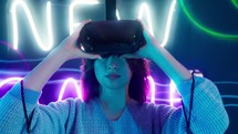 Woman putting on virtual reality goggles.