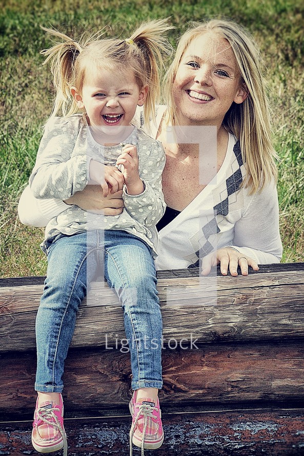 Mother and young daughter smiling