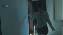 Woman stumbling through a hallway.