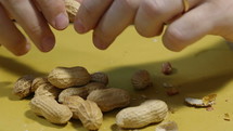 Person cracking peanut shells.