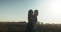 Happy mother and daughter playing in summer sunlight.