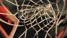 Close up of a basketball being shot on an outdoor basketball court on a sunny day