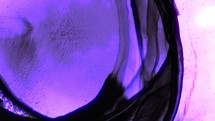 Dark Blue Paint Ink Spreading Over Purple Color, Abstract Cosmic Nebula. Close Up	