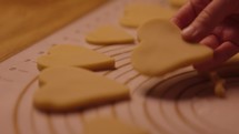 Young woman Cutting and examining heart shaped valentines day cookies