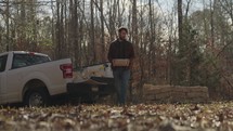 Man unloading bricks from a pickup truck and building an outdoor fire pit