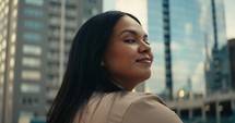 Young woman admiring downtown city buildings and scenery during sunset