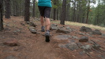 Low tracking shot of a man running on a forest trail
