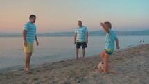 Men and Boy Playing Football on the Beach