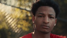 Portrait of a smiling young man playing basketball on a sunny day