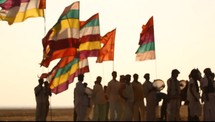 men with drums and flags in the desert 