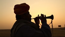 silhouette of a man playing a horn 