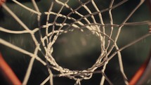 Close up of a basketball being shot on an outdoor basketball court on a sunny day