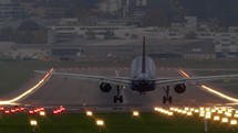View from behind of an airplane landing on a runway.