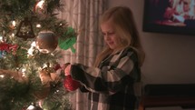 child decorating a Christmas tree 