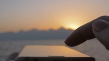 Smartphone in front of the evening sea landscape