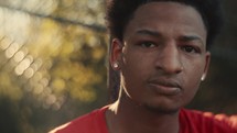 Portrait of a smiling young man playing basketball on a sunny day