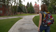 A young woman walking on a college campus